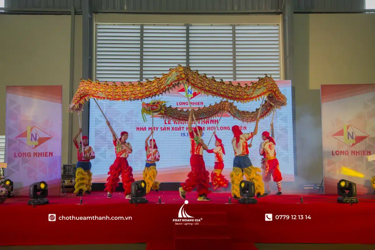 Âm thanh ánh sáng và vai trò của sân khấu trong lễ khánh thành 5 Tiết mục múa rồng biểu diễn trên sân khấu lễ khánh thành với ánh sáng sân khấu và màn hình LED hỗ trợ trải nghiệm khách mời