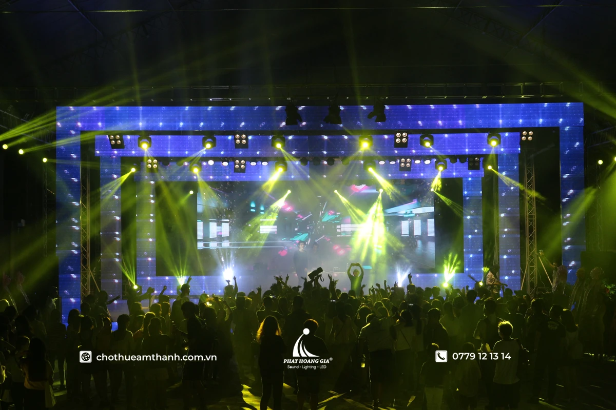 Rave Là Gì Và Văn Hóa Lễ Hội Âm Nhạc Điện Tử EDM 8 Rave là gì - sân khấu Rave với màn hình LED lớn, ánh sáng laser xanh và đám đông khán giả hòa mình vào không khí nhạc điện tử EDM