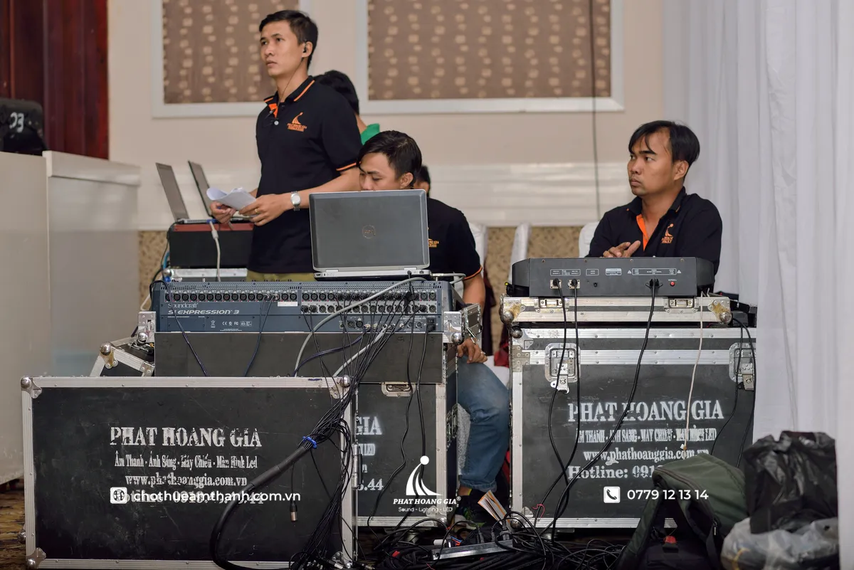 Kỹ thuật viên vận hành bàn mixer FOH, nơi dây multicore 24 line kết nối tín hiệu từ sân khấu đến hệ thống điều khiển, giúp đảm bảo truyền tín hiệu ổn định trong suốt chương trình.