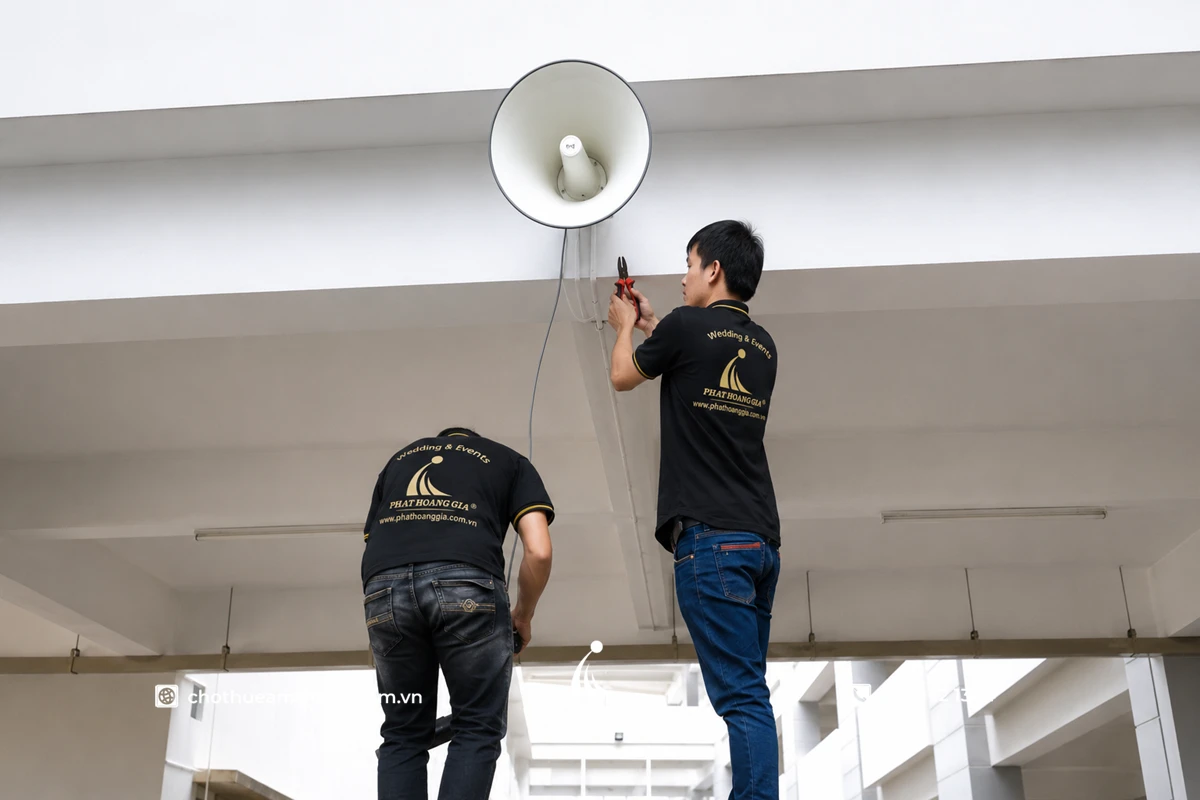 Kỹ thuật viên lắp đặt loa nén trong hệ thống âm thanh thông báo TOA cho trường học